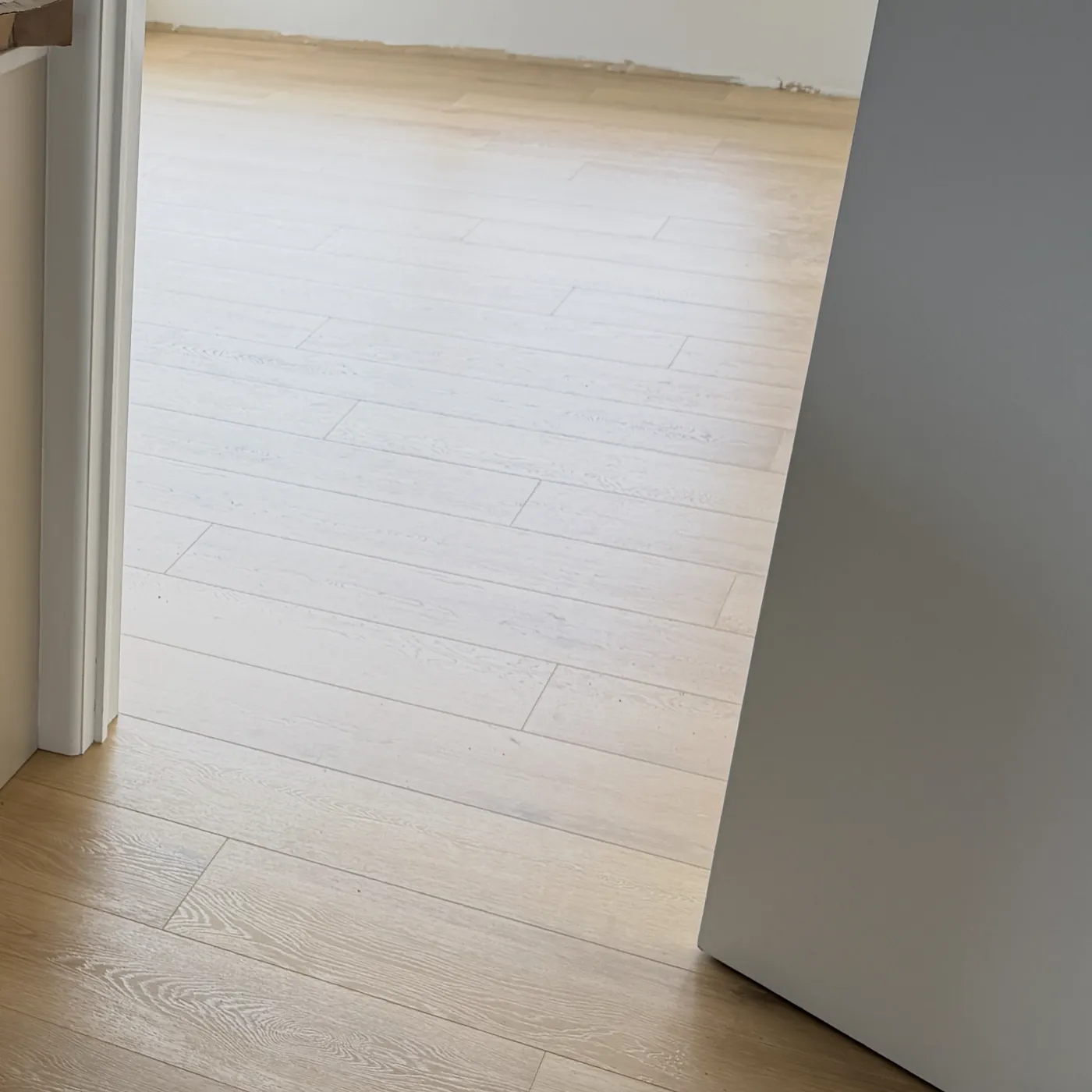 Laminate floor running through a bright doorway