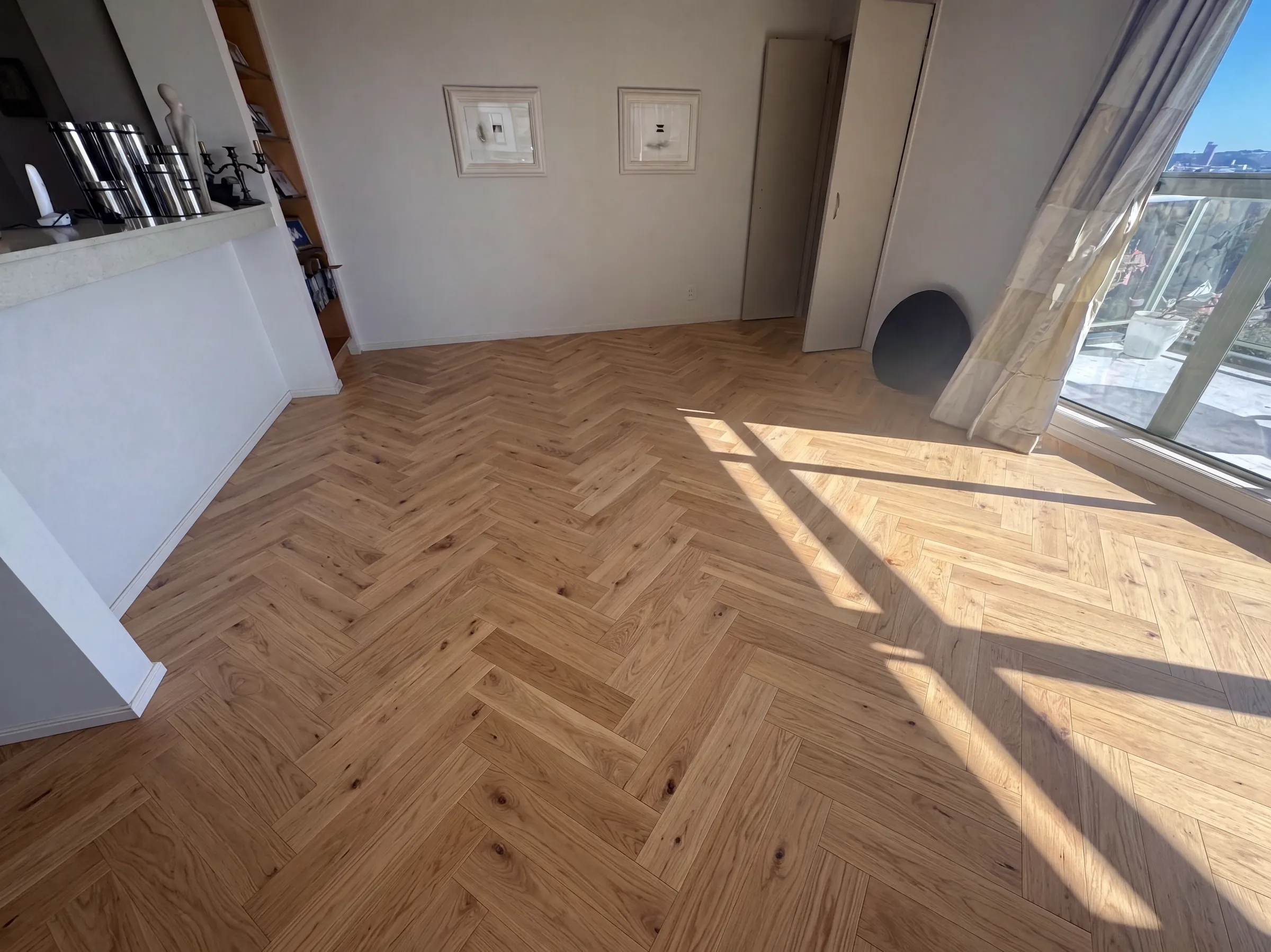 Caramel herringbone engineered timber in a sunlit apartment living room