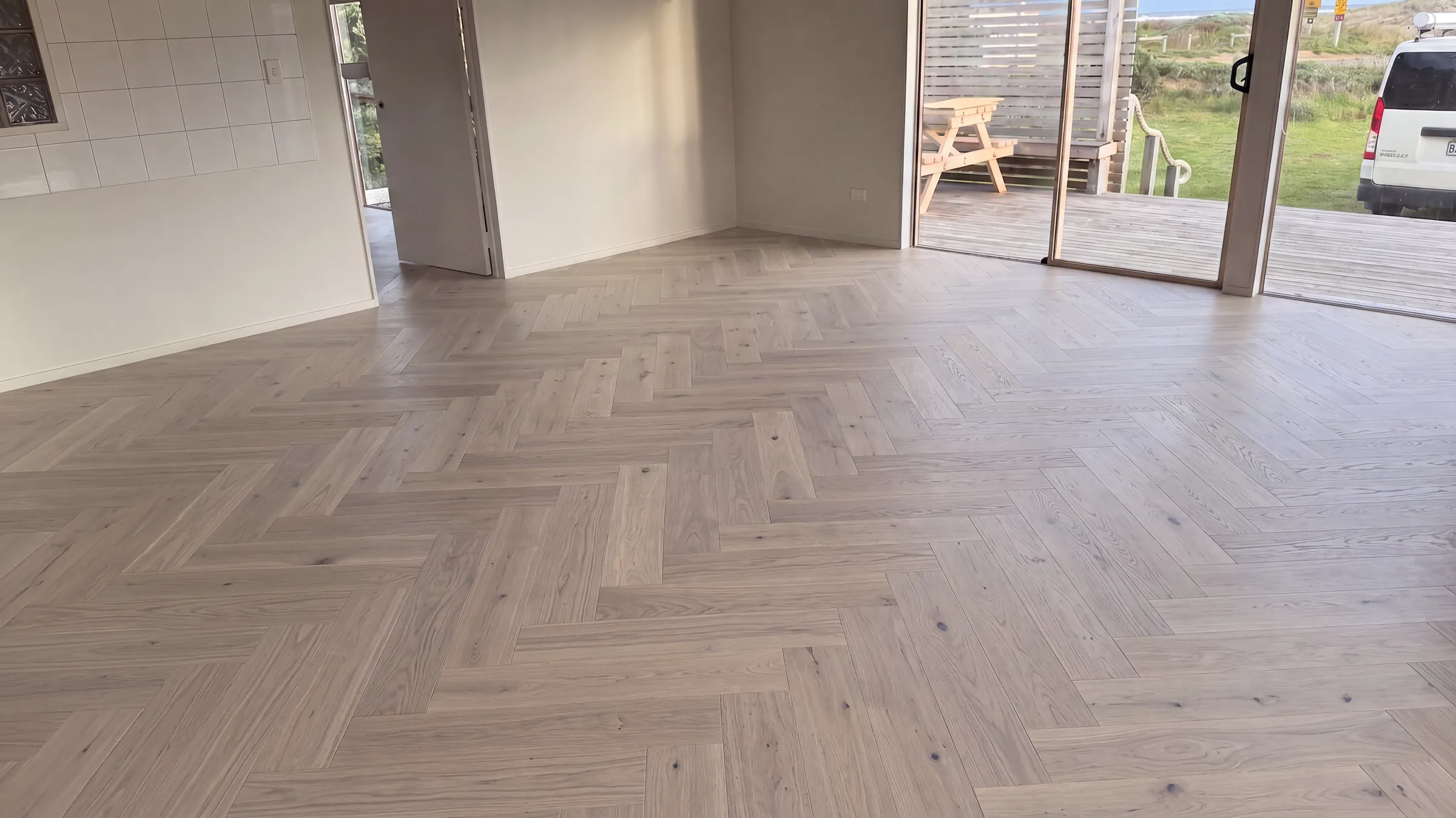 Latte herringbone engineered timber across an open plan new build living space
