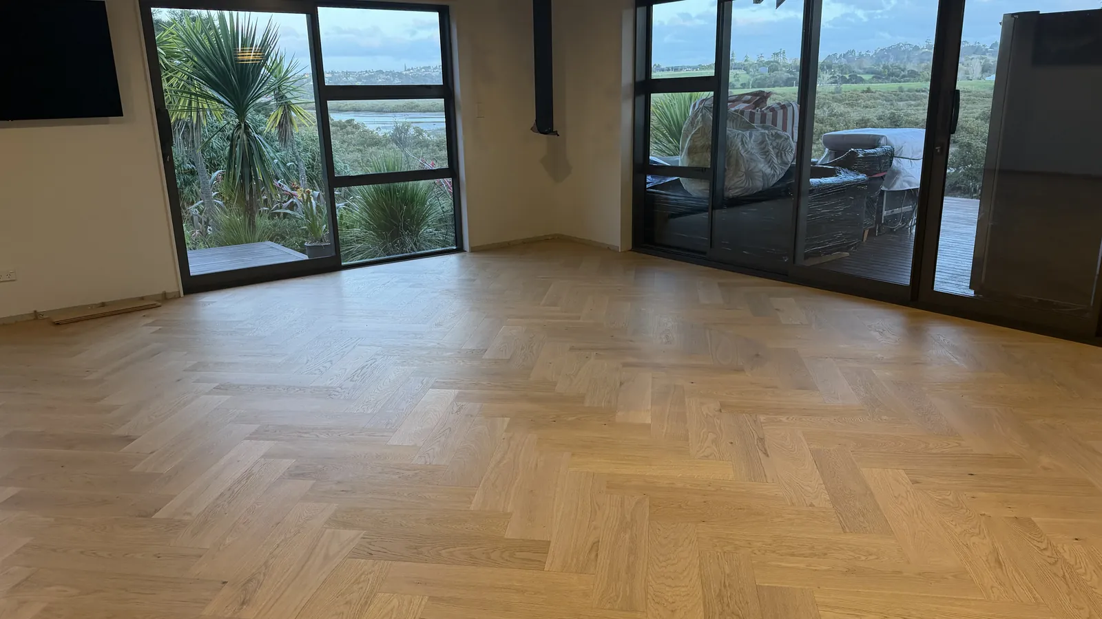 Natural Clear herringbone engineered timber by the windows at Whangaparaoa Road, Red Beach