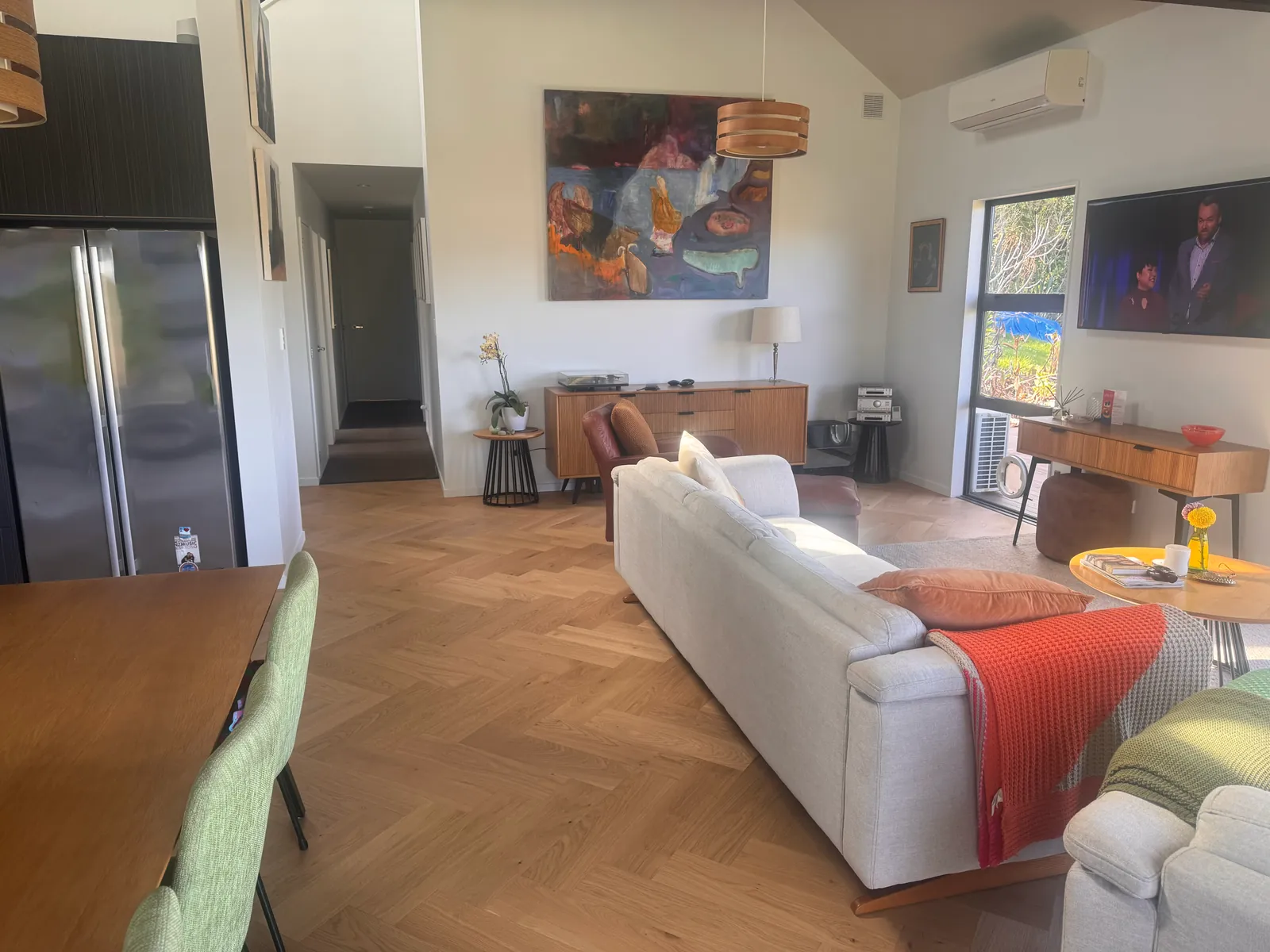 The furnished open plan living and dining space on Natural Clear herringbone at Whangaparaoa Road, Red Beach