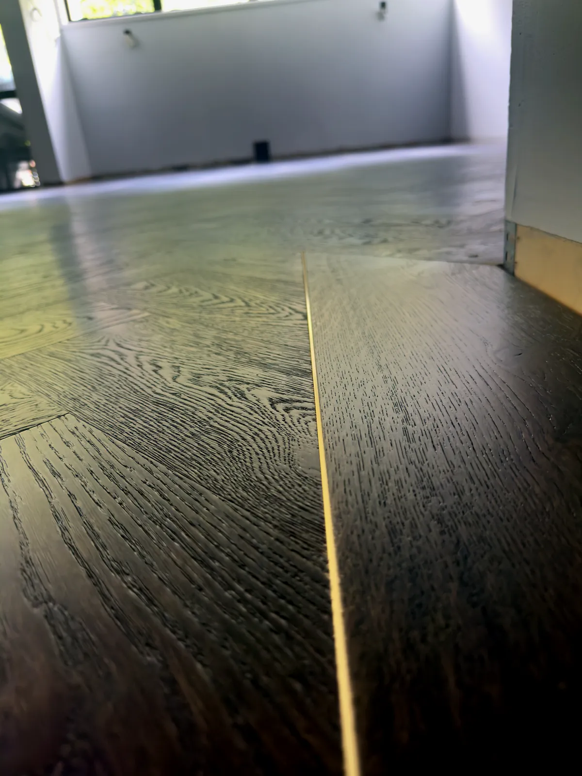 The gold L Channel Bar meeting Slate Grey herringbone engineered timber at the Manukau Hotel