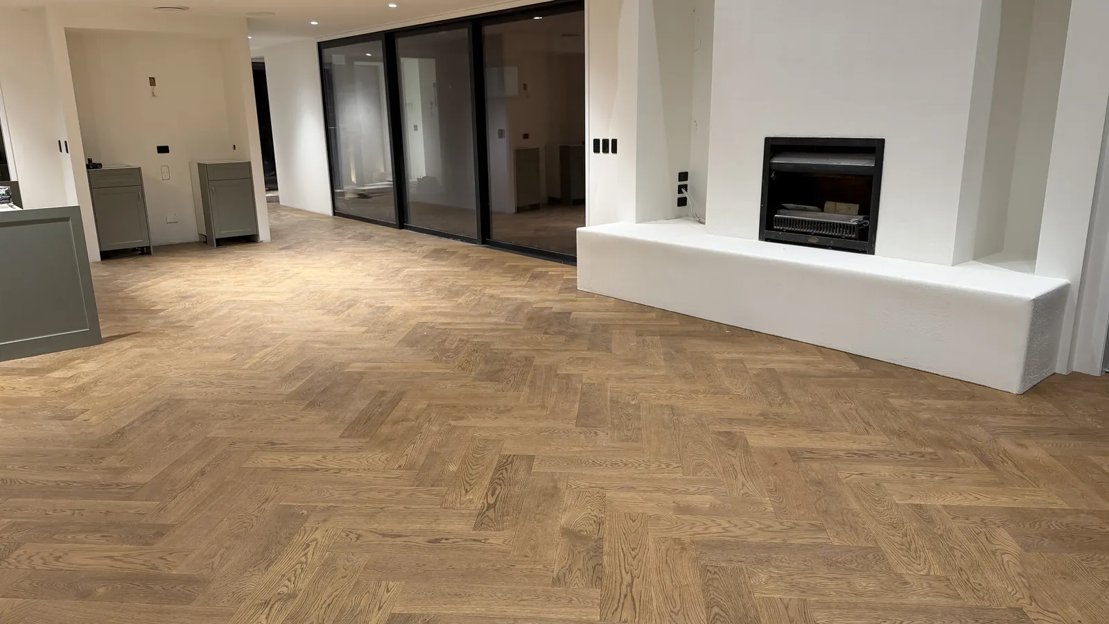Vintage herringbone engineered timber in the living room with the fireplace at Ellett Road, Karaka