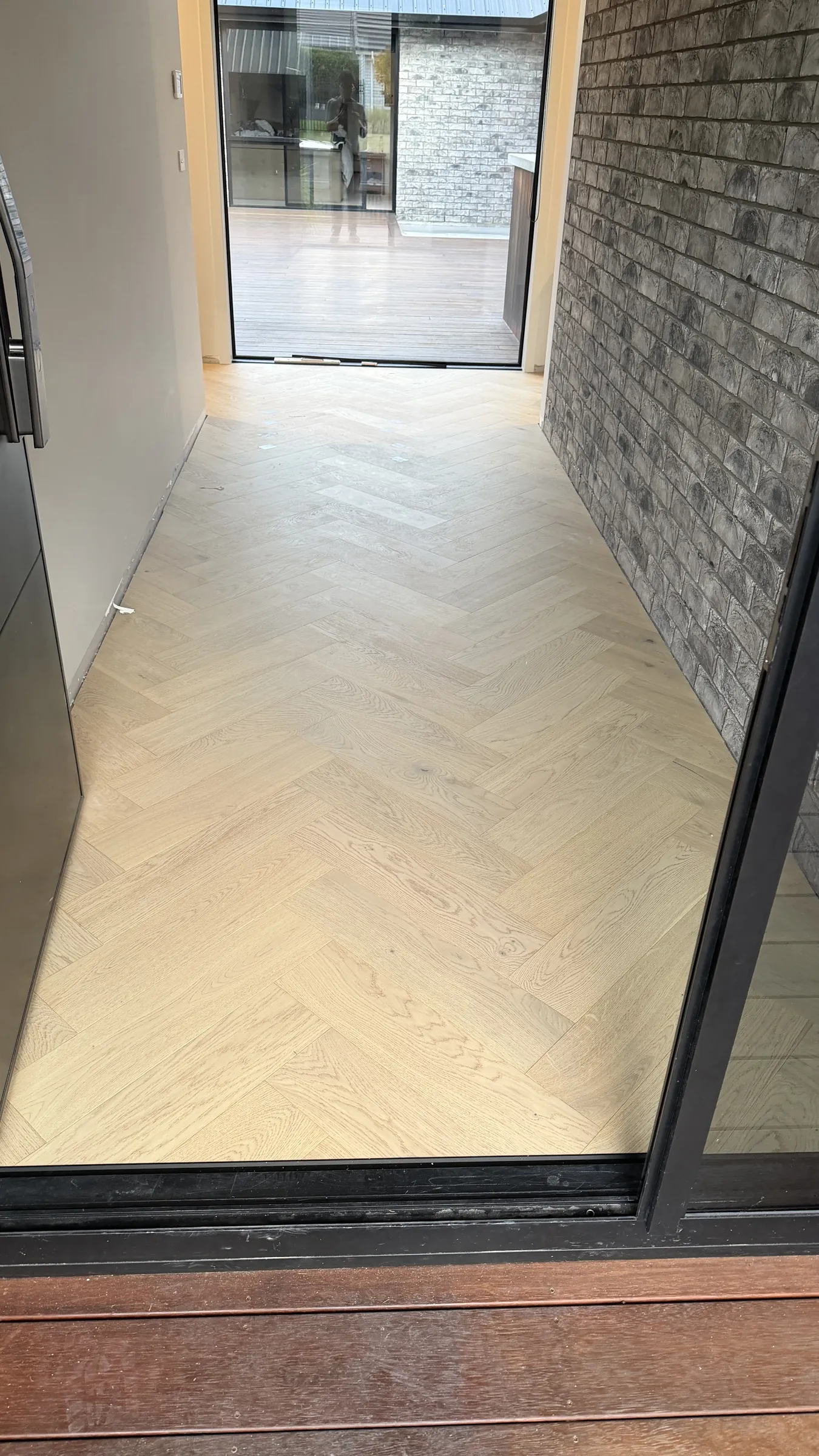 Western herringbone engineered timber meeting the brick wall at the entry of Whitford Park Road, Whitford