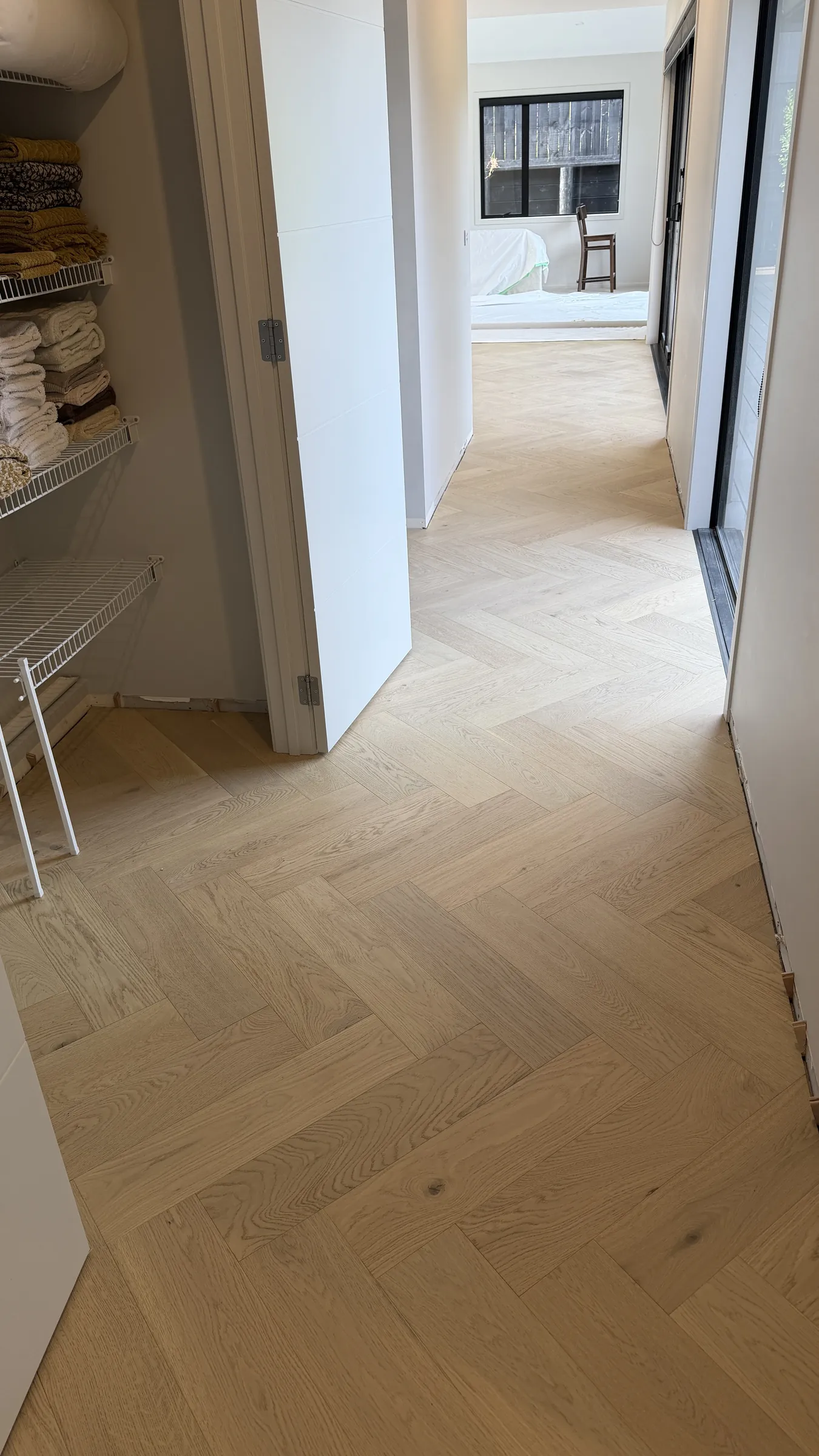 Western herringbone engineered timber running past the linen cupboard and through the doorways at Whitford Park Road, Whitford
