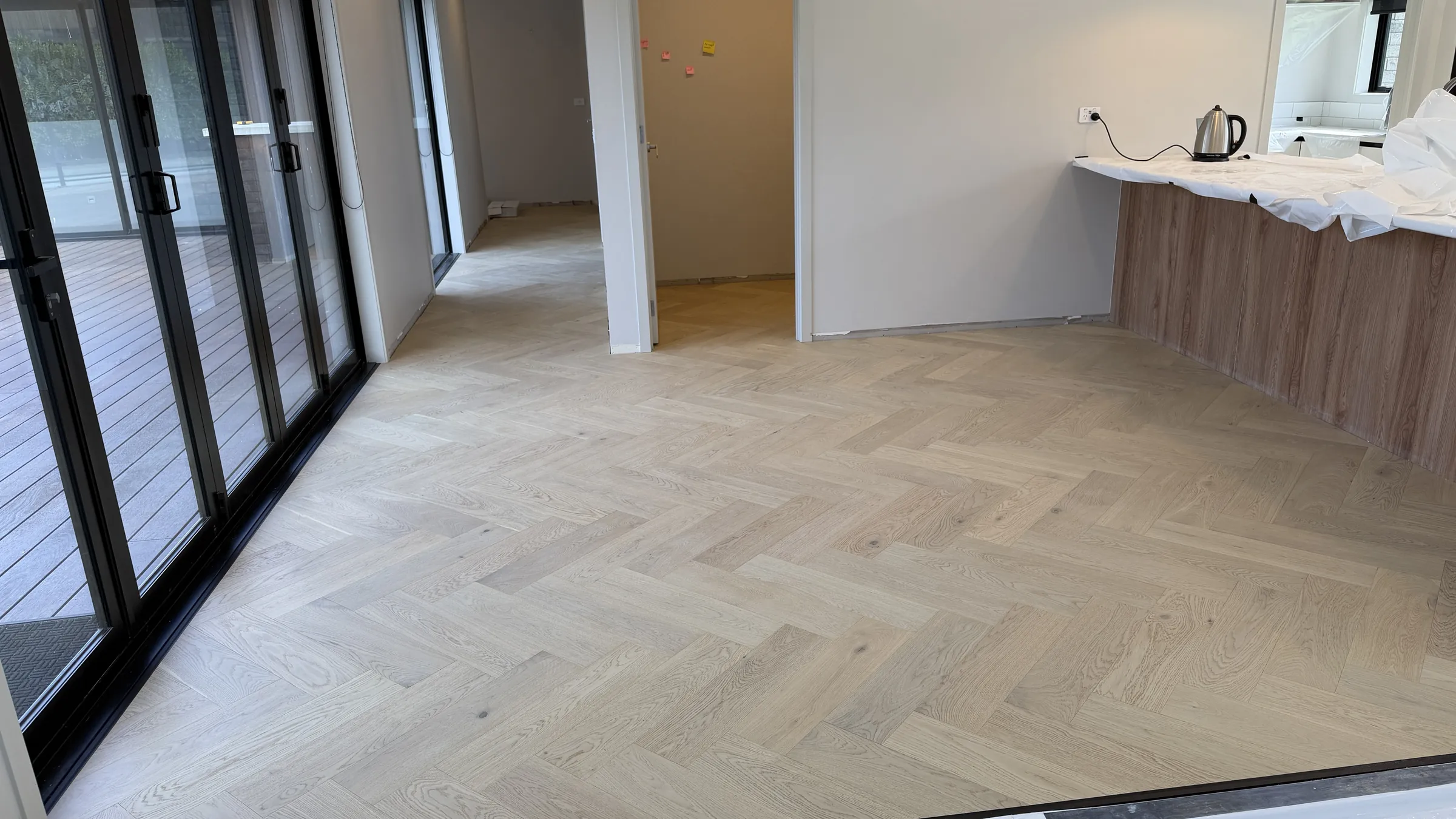 Western herringbone engineered timber across the open plan living space at Whitford Park Road, Whitford