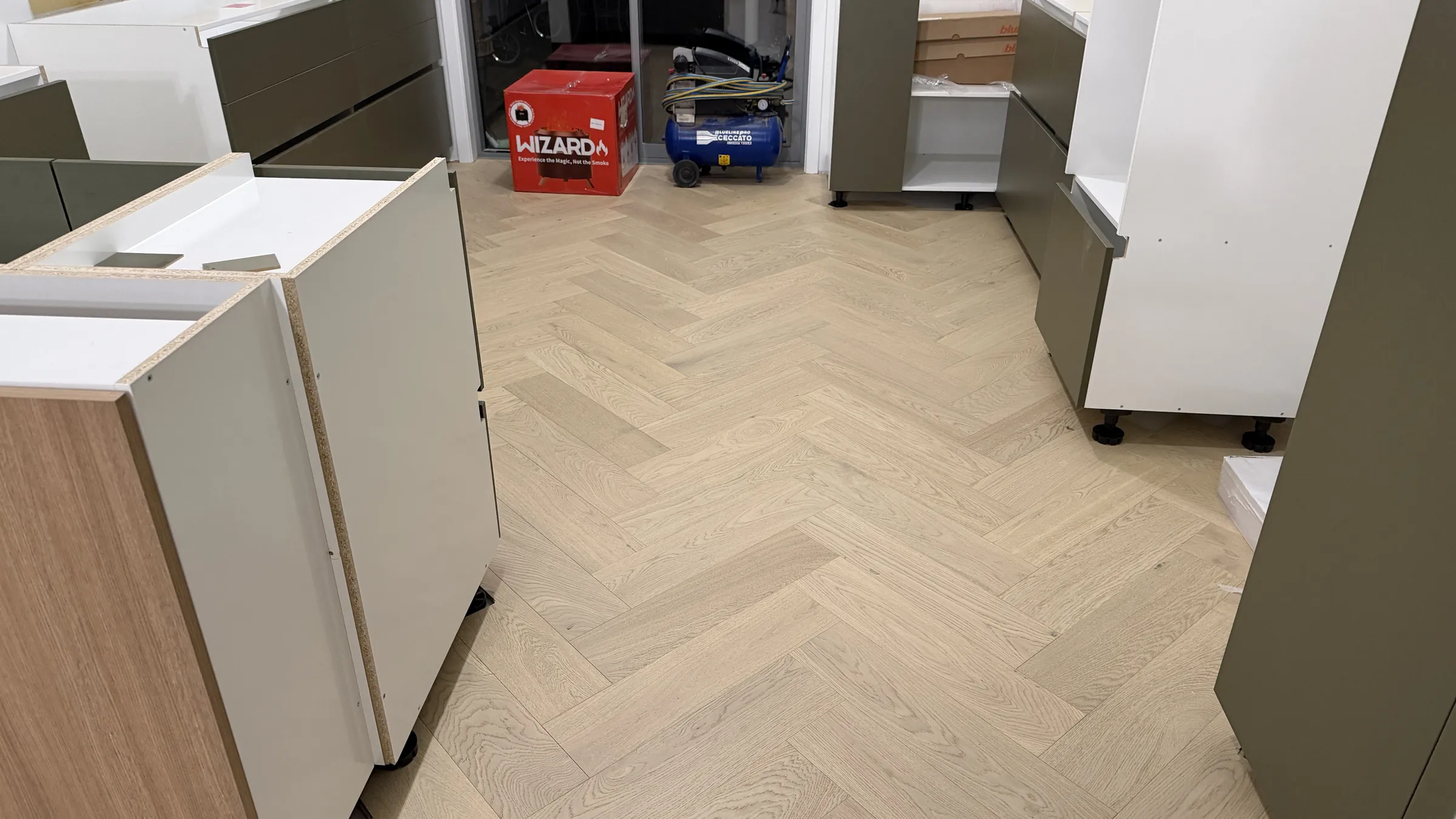 A new kitchen being fitted over freshly laid Western herringbone engineered timber at Shaw Road, Oratia