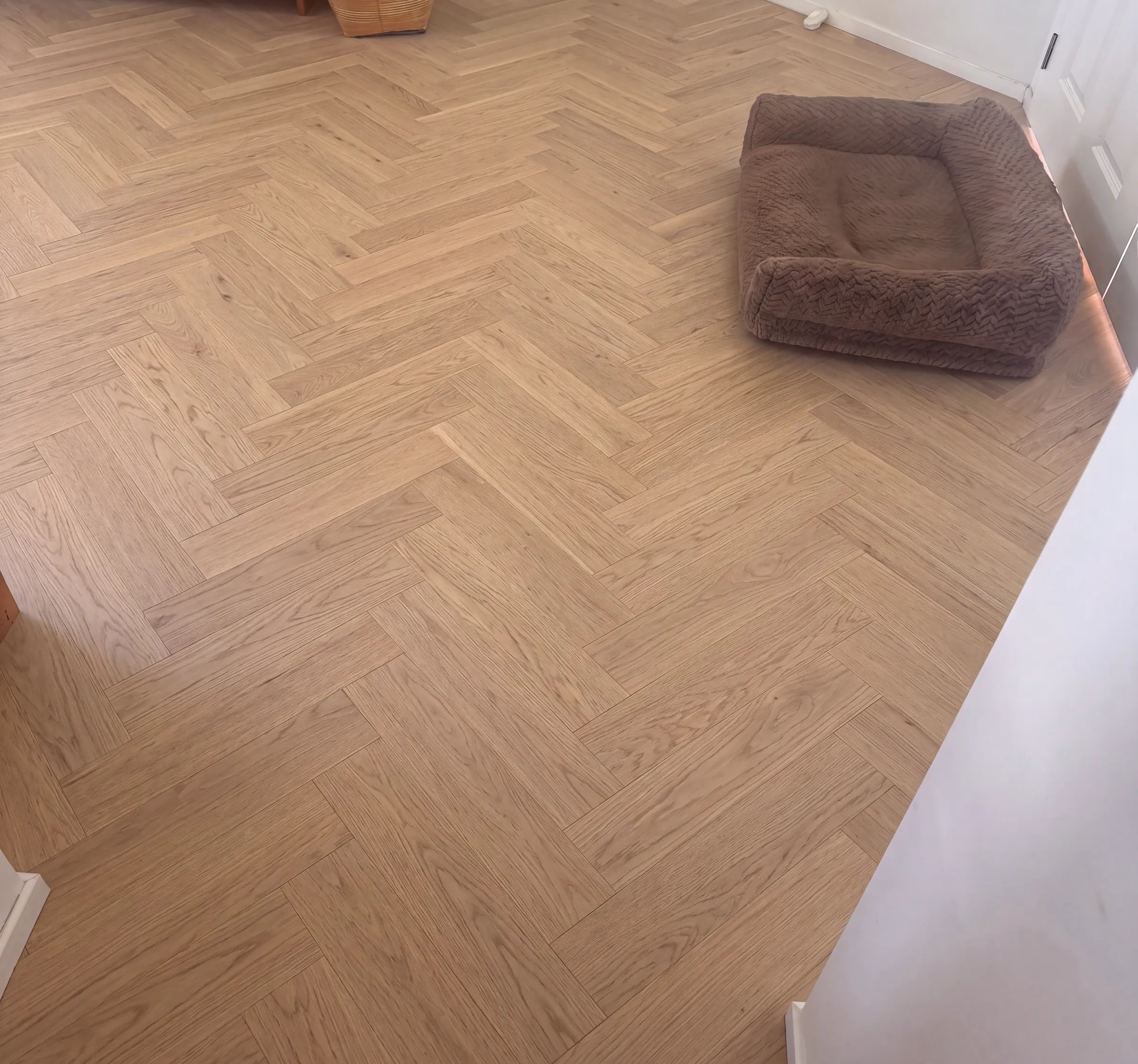 Wheat herringbone engineered timber in a living room, the dog bed already in place