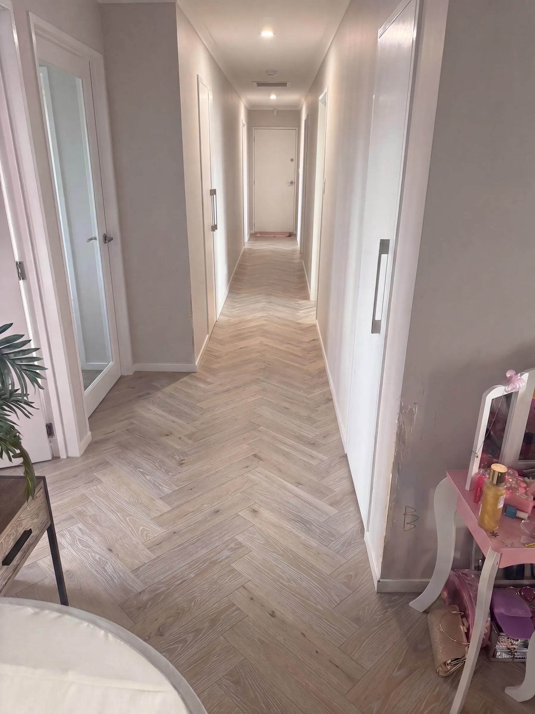 White Wash herringbone engineered timber running the full length of a hallway