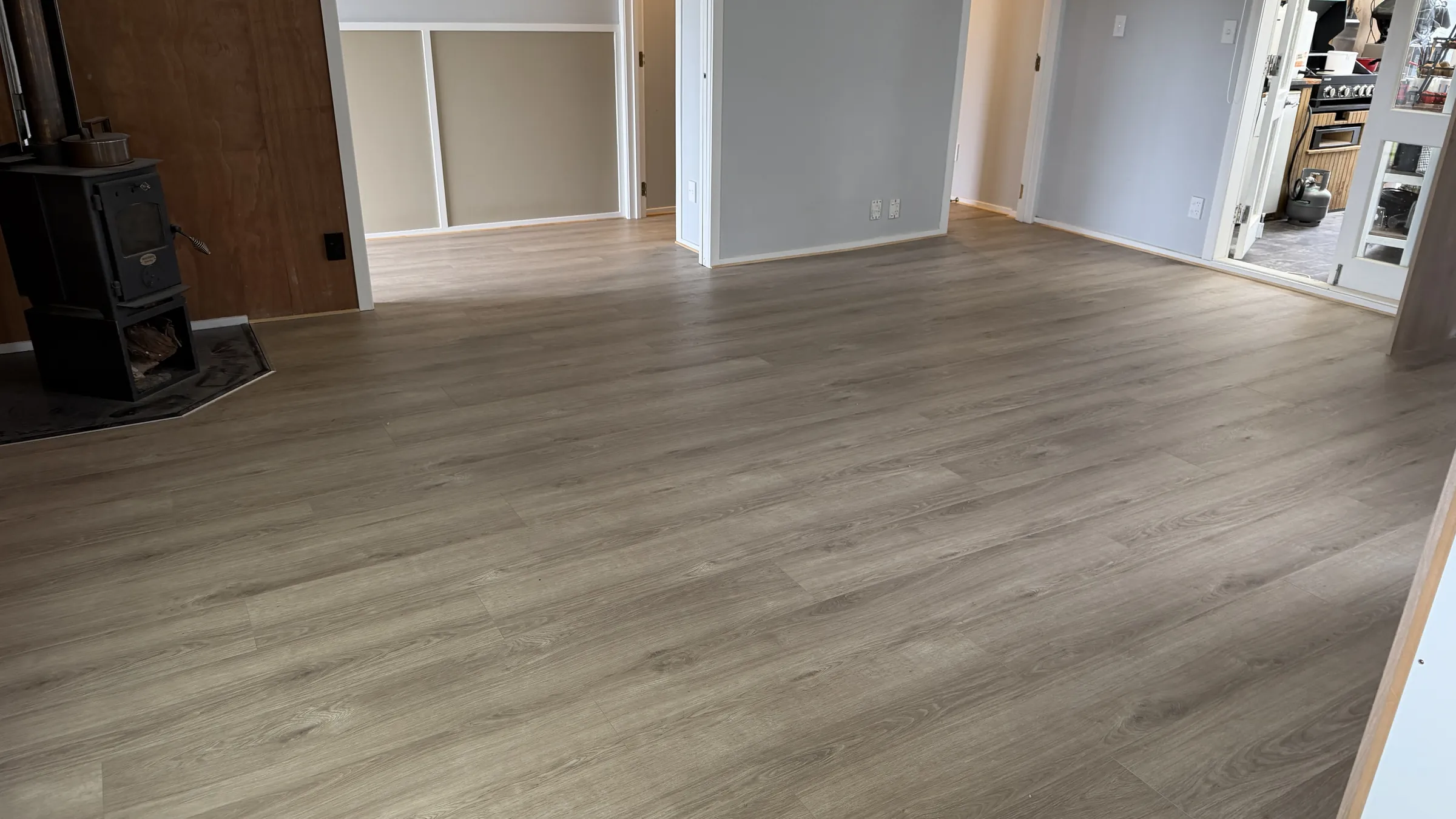 270-10 laminate through the living room at Prictor Road, Wellsford, the log burner in the corner