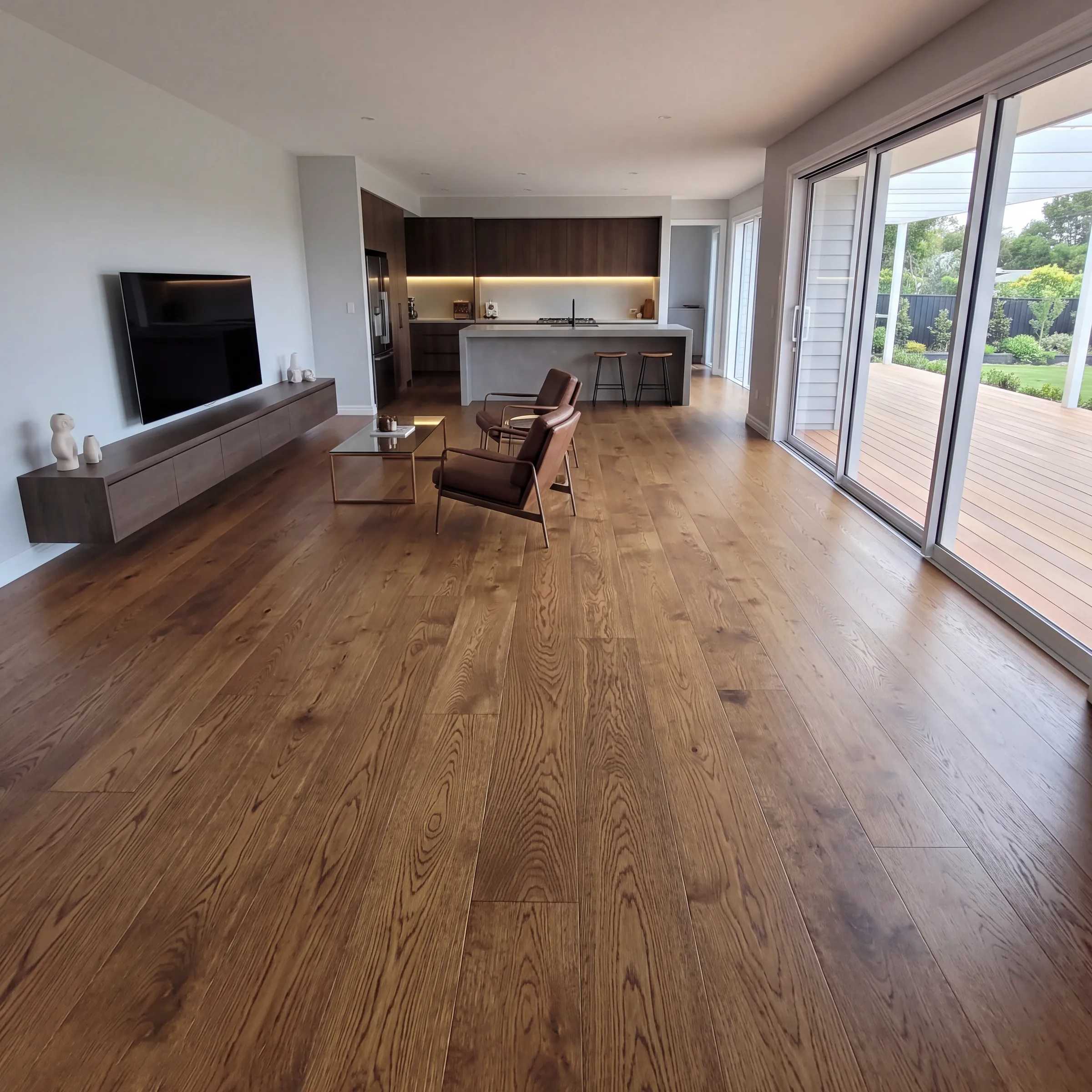 Vintage oak plank through an open living room and kitchen, sliding doors to the deck