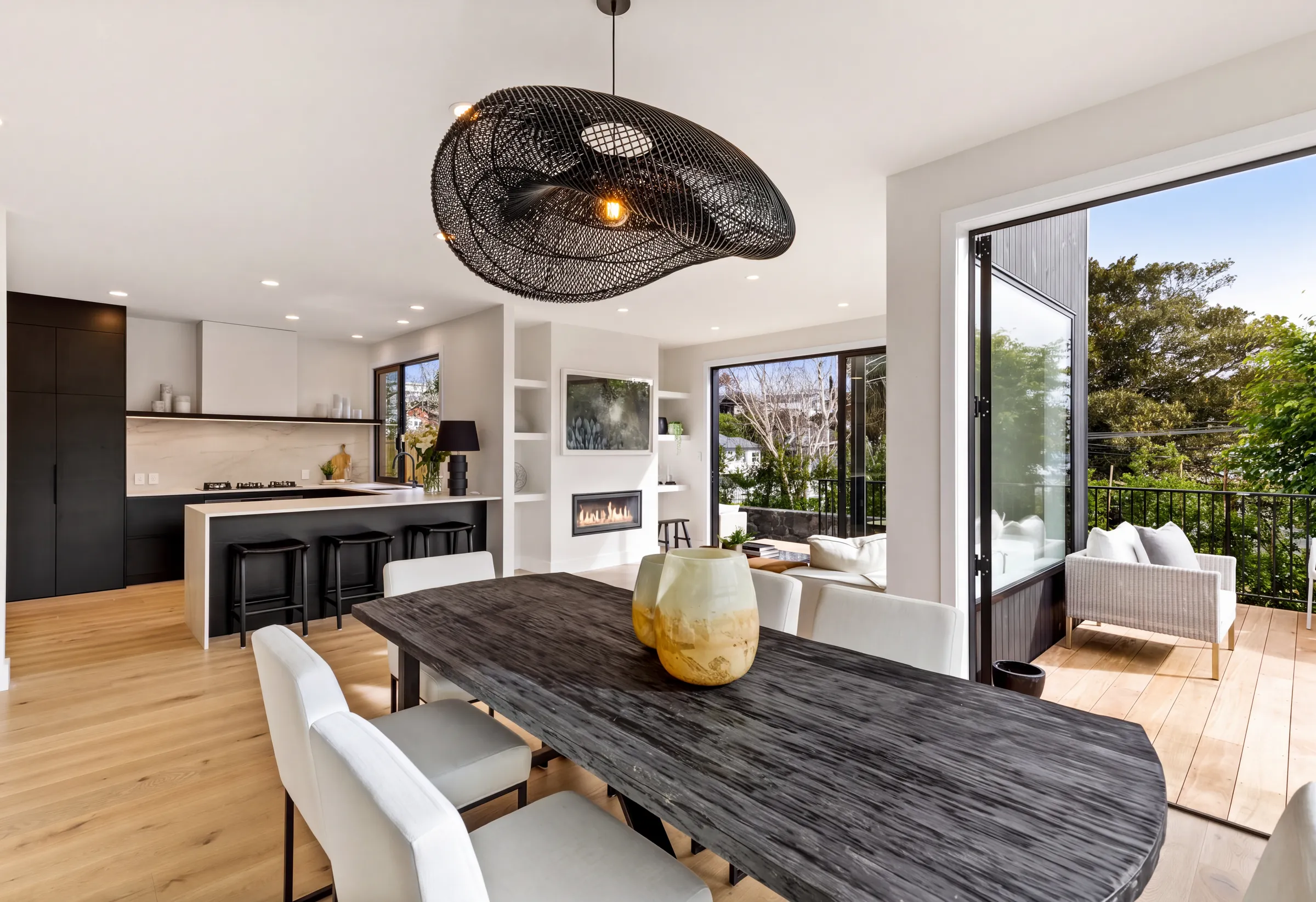 Western oak plank under the dining table and woven pendant at Domain Crescent, Muriwai