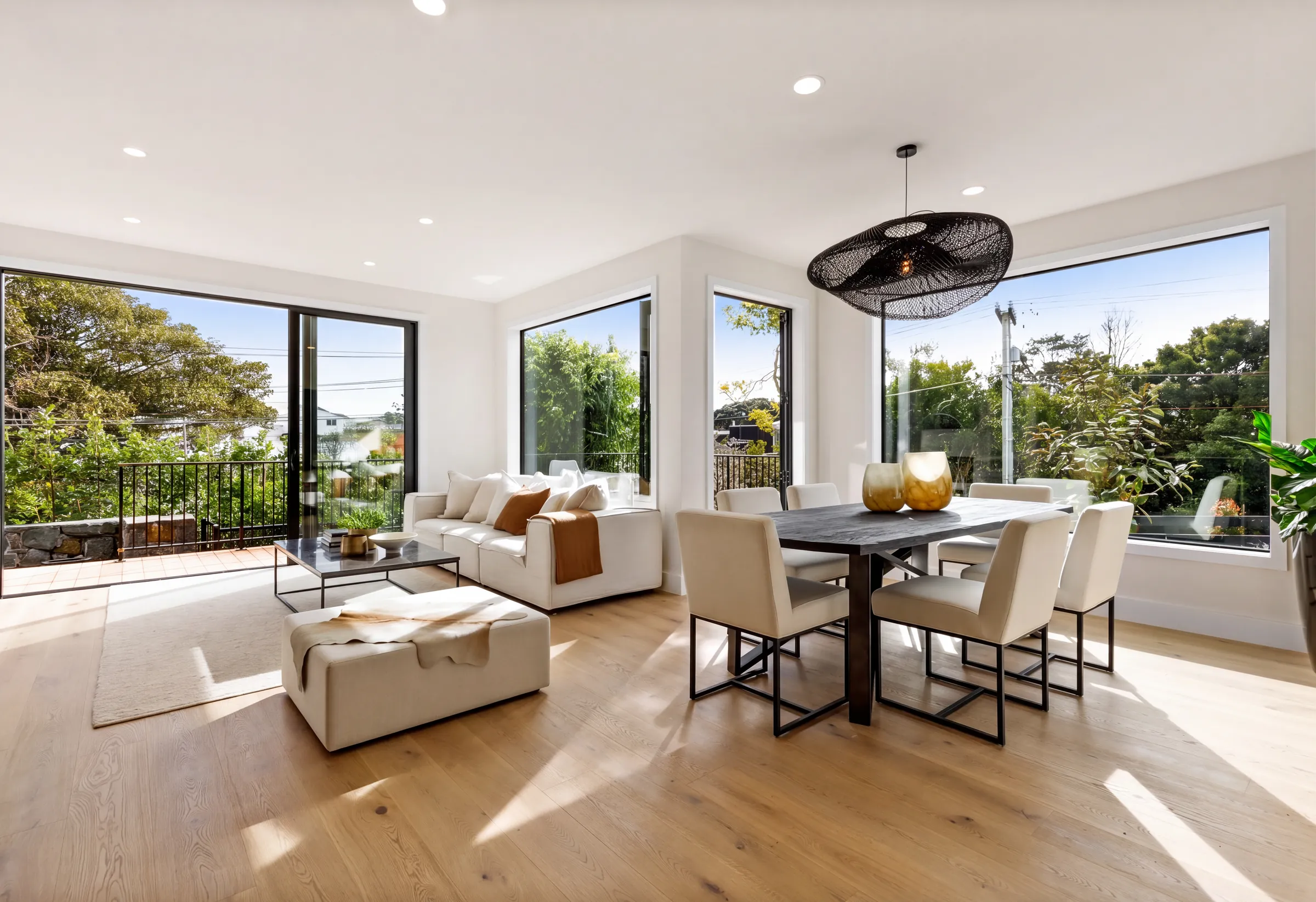 Western oak plank across the sunlit living and dining room at Domain Crescent, Muriwai