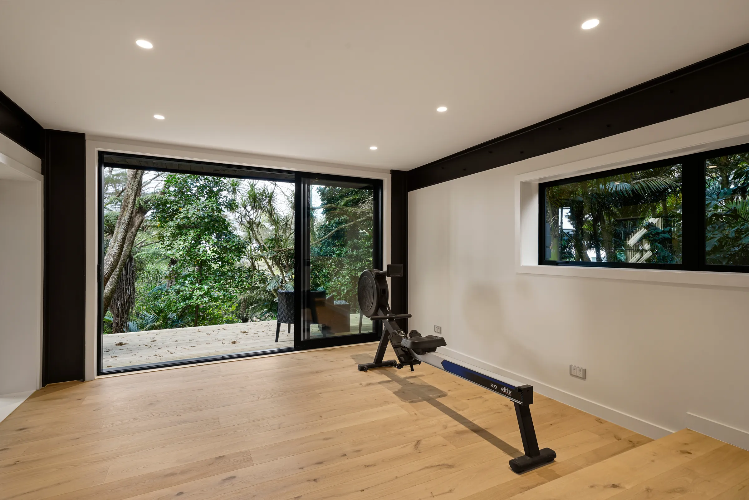 The gym with garden windows over Raw 260 wide engineered timber at Seaview Road, Remuera
