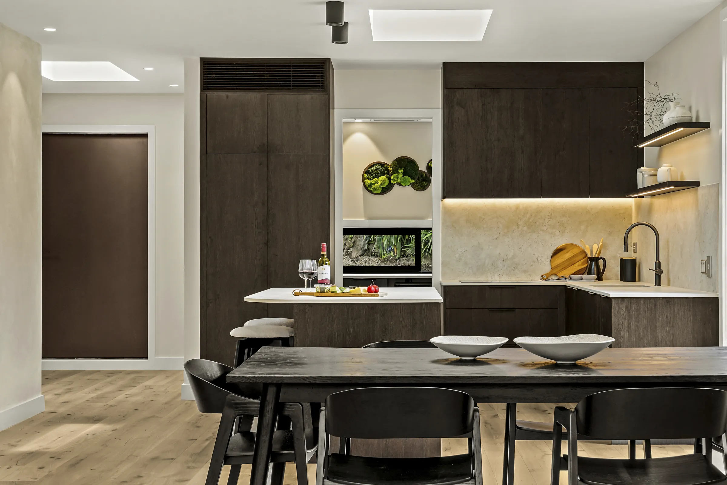 Dark timber cabinetry and a stone splashback over Raw 260 wide engineered timber at Seaview Road, Remuera