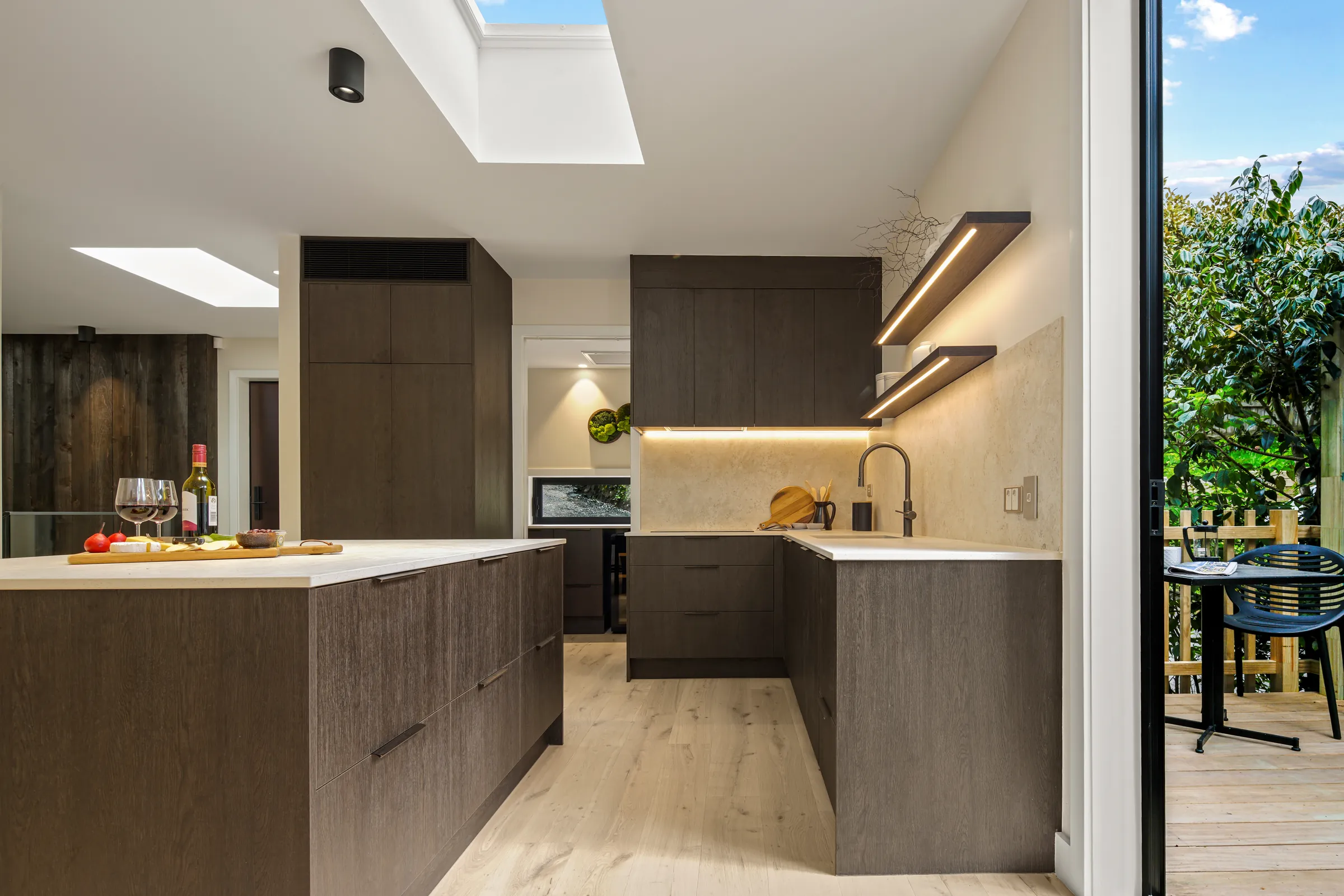 The kitchen island under skylights on Raw 260 wide engineered timber at Seaview Road, Remuera