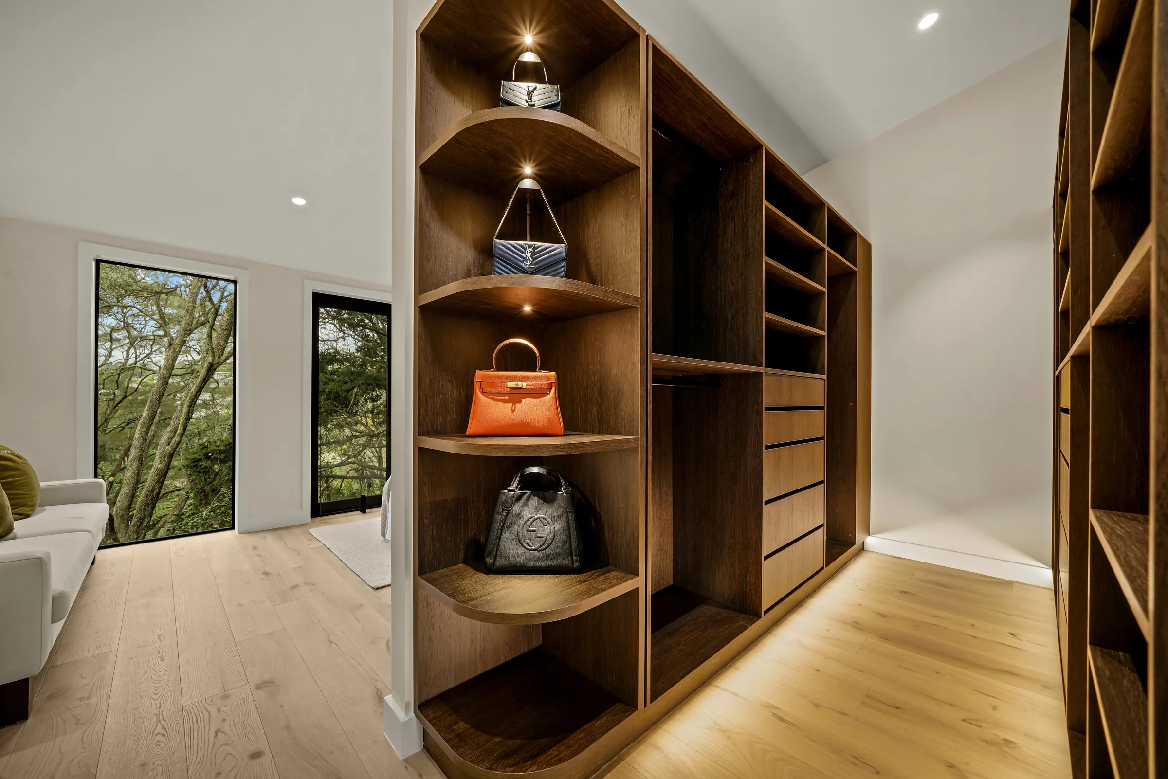 The walk-in wardrobe with lit shelving over Raw 260 wide engineered timber at Seaview Road, Remuera