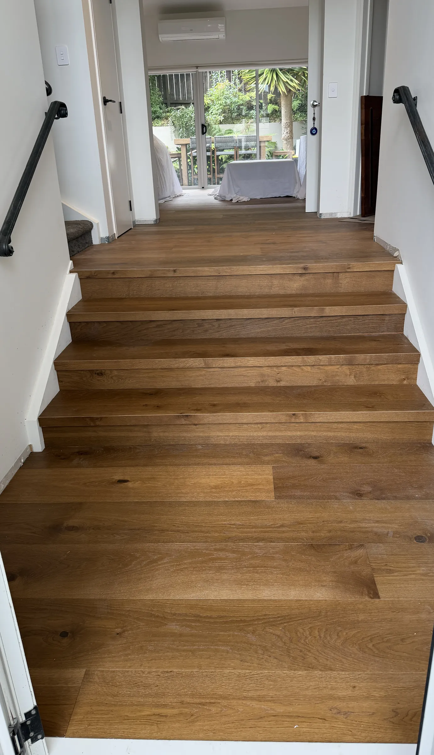 Wide stairs in ATS Timber Caramel Roast rising toward the living room at Rosewell Crescent, Flat Bush