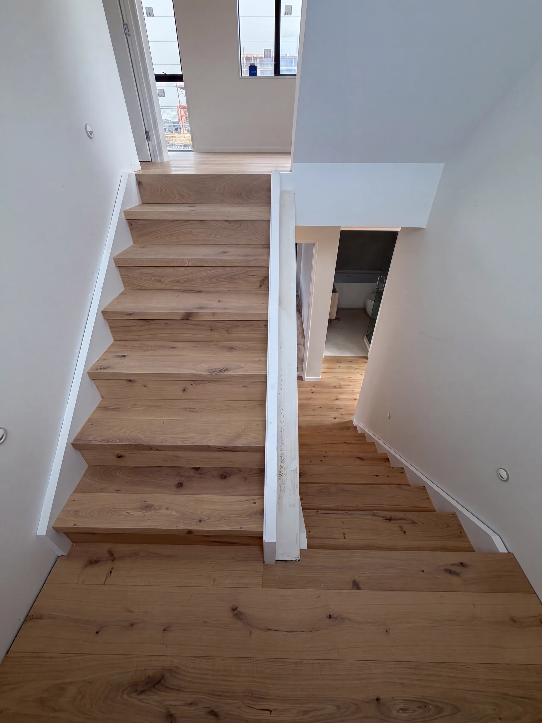 A Light Oak staircase descending to a mid landing at Manapau Street, Meadowbank