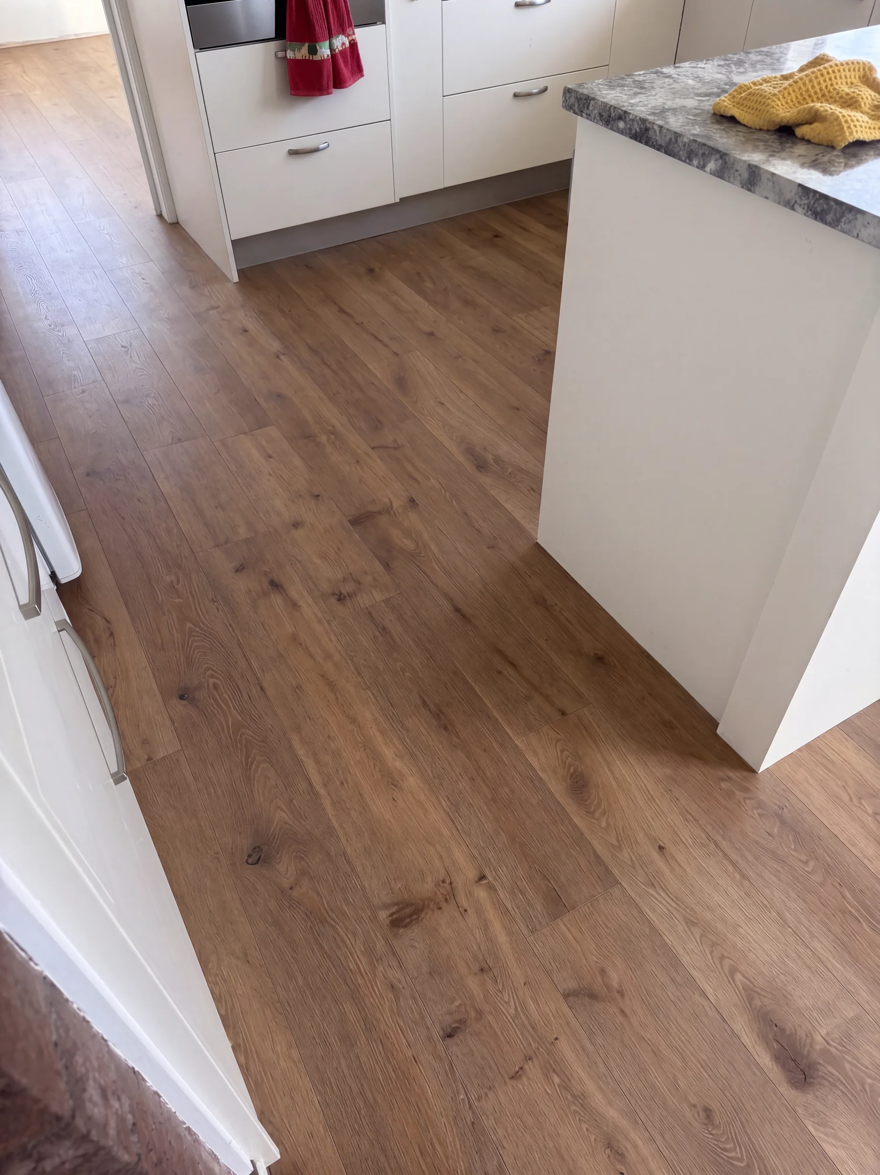 ATS Timber Drift flooring through a white kitchen at Surf Road, Stanmore Bay