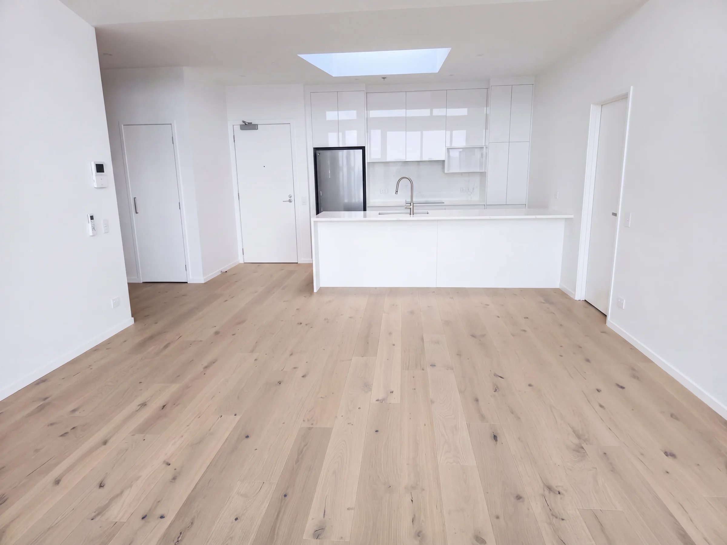 ATS Timber Latte Luxury 190mm flooring toward the white kitchen at The Nautilus, Orewa