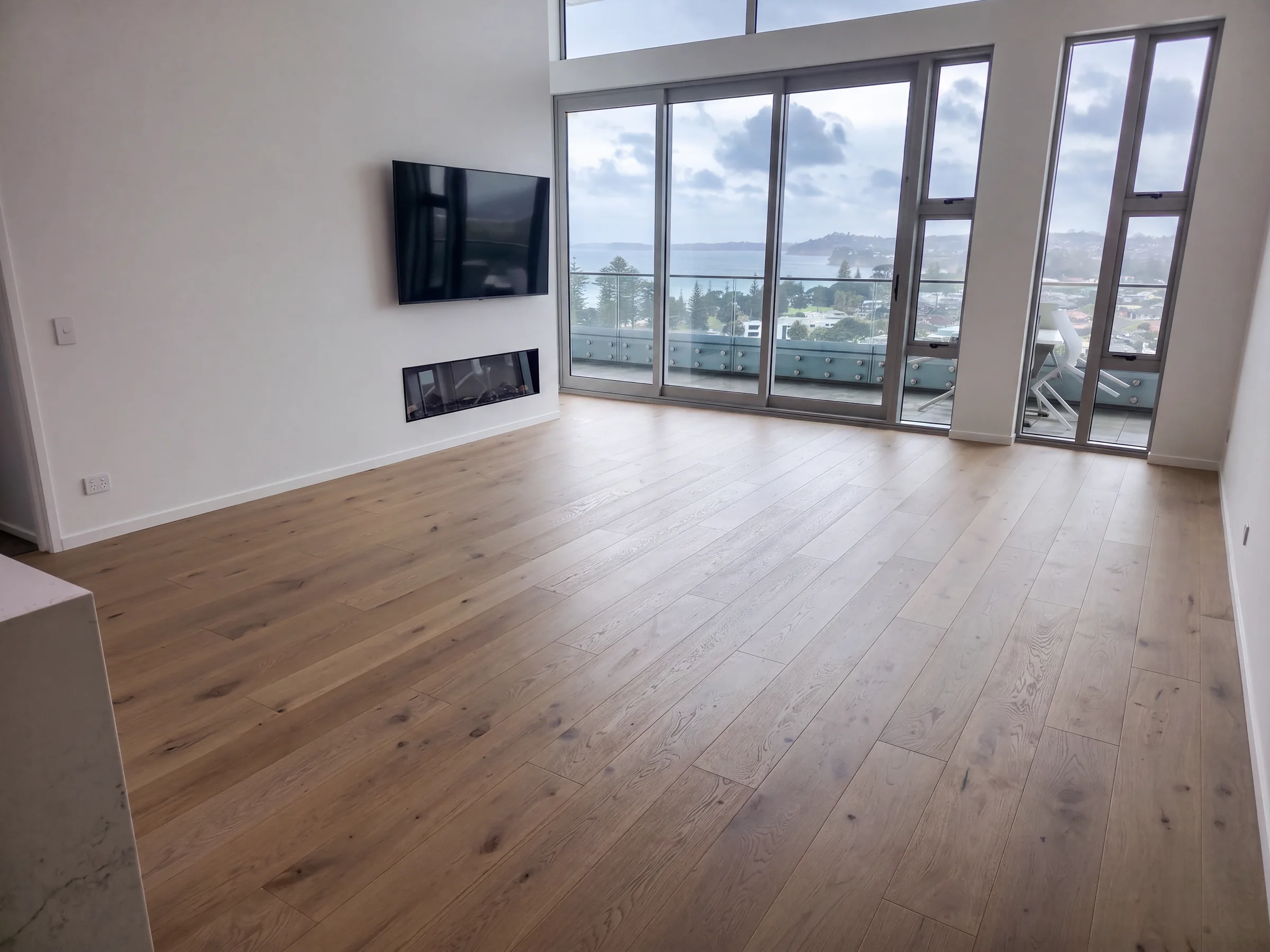 ATS Timber Latte Luxury 190mm flooring in a living room overlooking Orewa beach