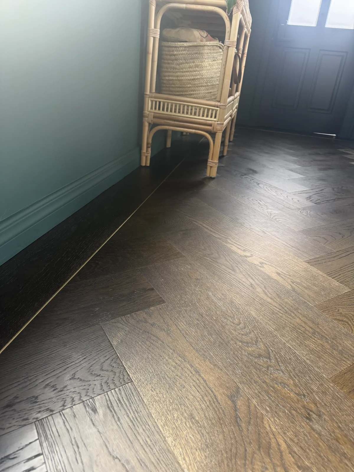 Slate Grey herringbone with Oak Plank border and gold L Channel Bar beside a deep green wall at Kitchener Road, Milford